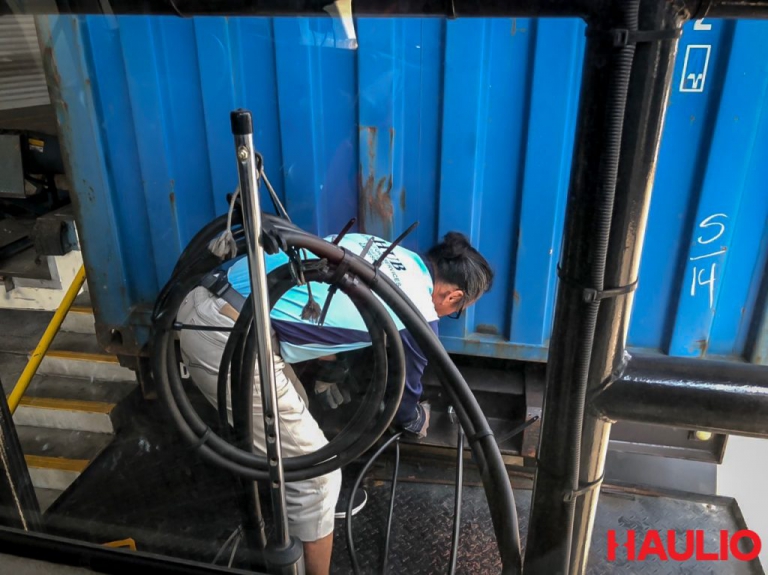 Uncle Foong ensuring that the container is securely latched onto the prime mover