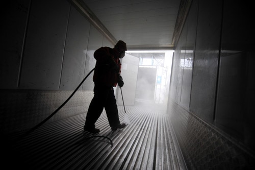 Man cleaning interior of a contianer